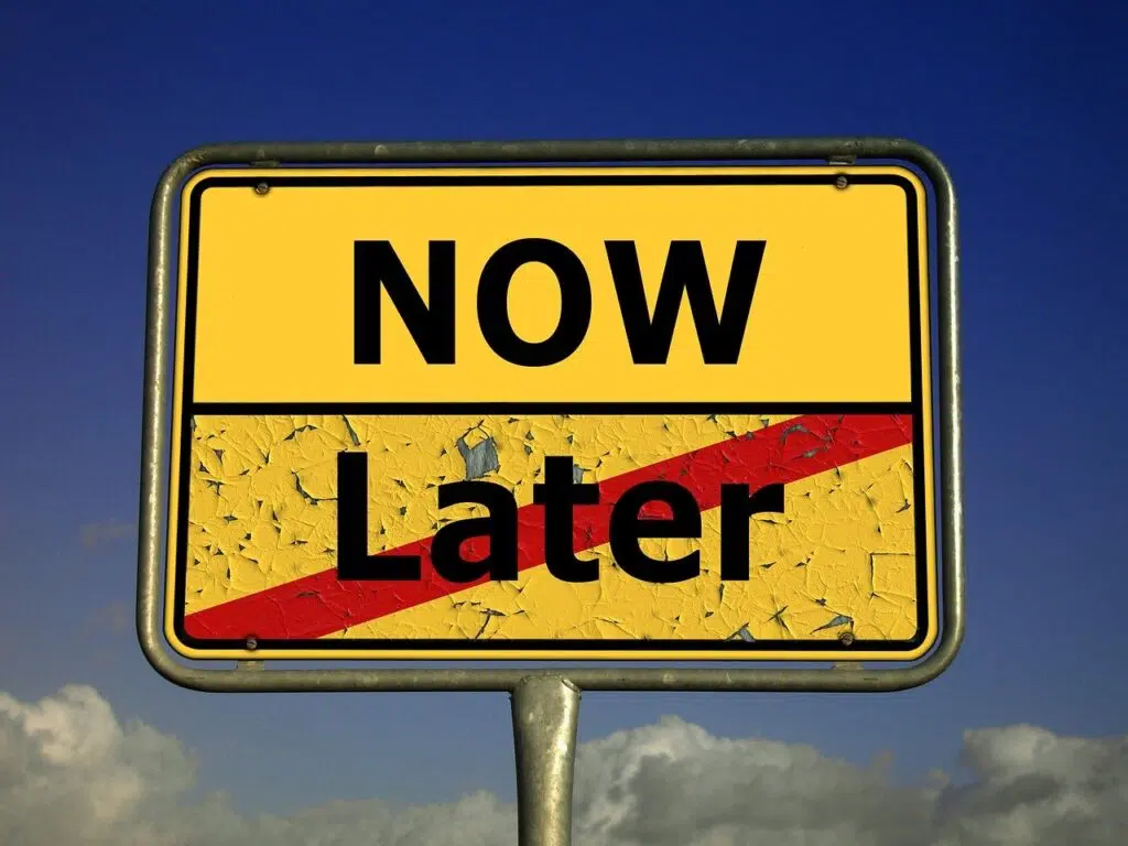 Procrastination thoughts. A yellow street sign with "NOW" at the top and "Later" crossed out with a red slash at the bottom, against a blue sky with clouds, representing a decision to take action immediately. Zip Codes: Austin area 78746, 78730, 78733, 78739, 78732, 78701, 78703. Round Rock area 78681, 78665, 78641, 78717, 78613.